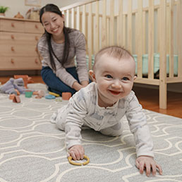 Babysitter playing with a crawling infant.