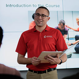 An American Red Cross instructor speaking in front of a group of people.