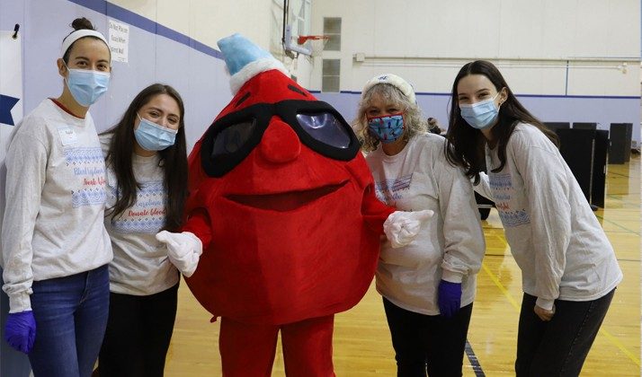 3 Nursing Students are posing for a picture with the Red Cross Blood mascot